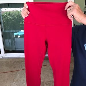 Lululemon red leggings with gold branding.